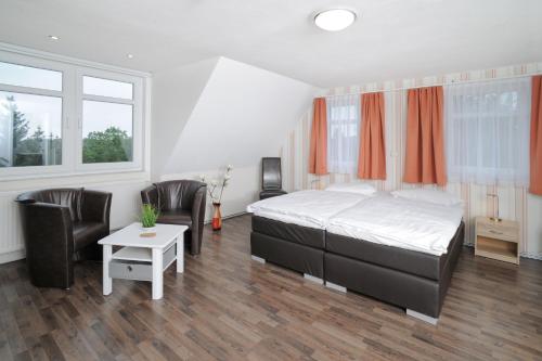 a bedroom with a bed and a table and chairs at Le petit Palais - Apartments in Bad Suderode