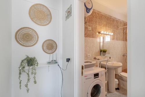 a bathroom with a washing machine and a toilet at Uga La Dehesa I in Uga