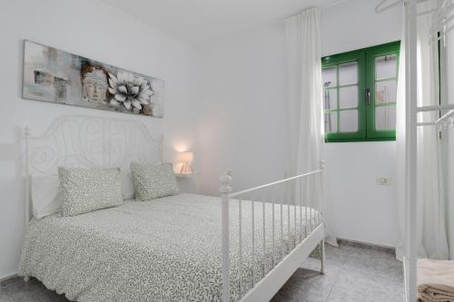 a white bedroom with a white bed and a window at Uga La Dehesa I in Uga