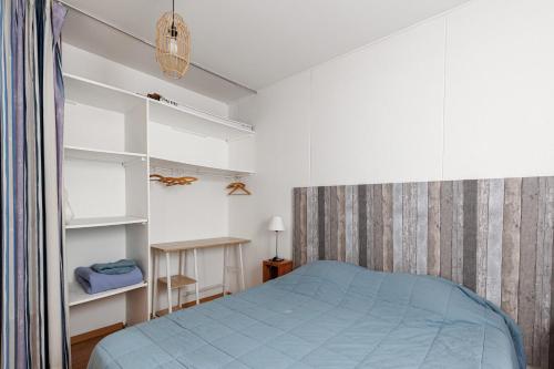 a bedroom with a blue bed and white cabinets at Villa du Lac - Conciergerieland in Soustons