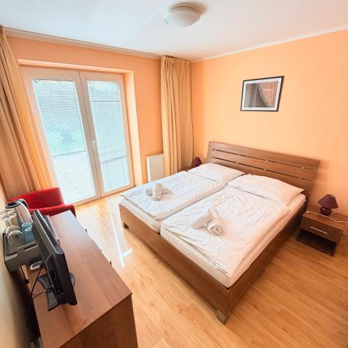 a bedroom with a large bed and a television at Terra Wylak Winery in Veľké Zálužie