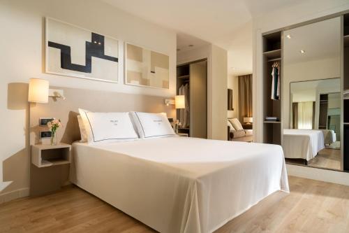 a bedroom with a large white bed and a living room at Helios Benidorm in Benidorm