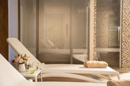 a bathroom with a white chair and a mirror at Helios Benidorm in Benidorm