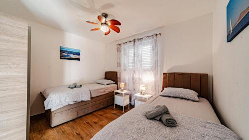 a bedroom with two beds and a ceiling fan at MAB Sweet Home By Villas Guide in Vela Luka