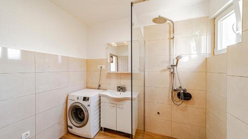 a bathroom with a washing machine and a washer at MAB Sweet Home By Villas Guide in Vela Luka