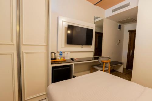 a hotel room with a bed and a desk with a television at Mai İnci Pera Hotel İstanbul in Istanbul