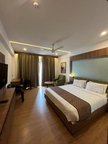 a bedroom with a large bed and a television at MANDARIN SKY in Kannur