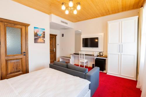 a bedroom with a bed and a couch and a tv at Mai İnci Pera Hotel İstanbul in Istanbul
