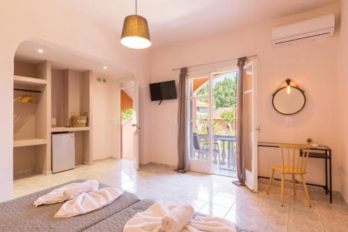 a bedroom with a bed and a table and a window at Garden Budget Rooms By Dominoes Corfu in Ipsos