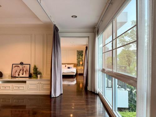 a bedroom with a bed and a large window at Pool Villa Ramkhamhaeng 9 in Bangkok