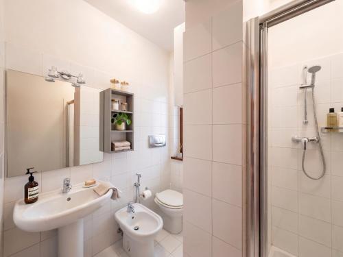 a white bathroom with a sink and a toilet at Piccola Corte in Fano