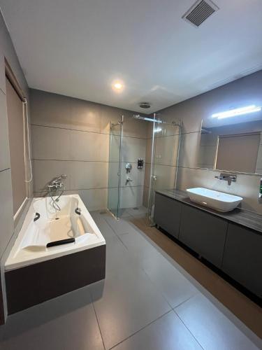 a bathroom with a sink and a glass shower at MANDARIN SKY in Kannur