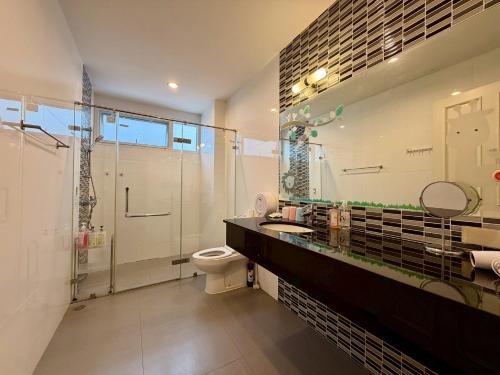 a bathroom with a shower and a toilet and a sink at Pool Villa Ramkhamhaeng 9 in Bangkok