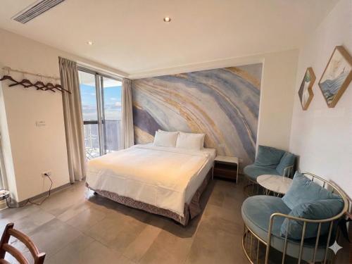 a bedroom with a bed and a painting on the wall at 會呼吸的房-採自助式入住-有電梯 in Huwei