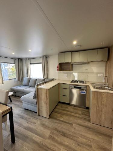 a kitchen and a living room with a couch at Escapade in Lège-Cap-Ferret