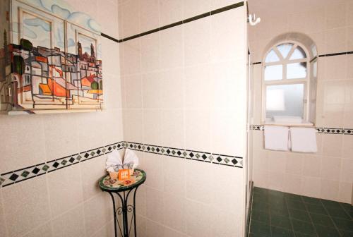 y baño con ducha, mesa y ventana. en Hotel & Suites Galeria, en Morelia