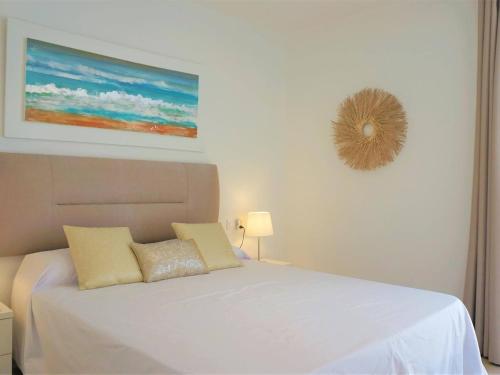 a bedroom with a white bed and a picture on the wall at La perla del mar 1 in Son Servera