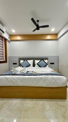 a bedroom with a bed with a ceiling fan at TCS SUITES Chala Bypass Kannur in Thottada