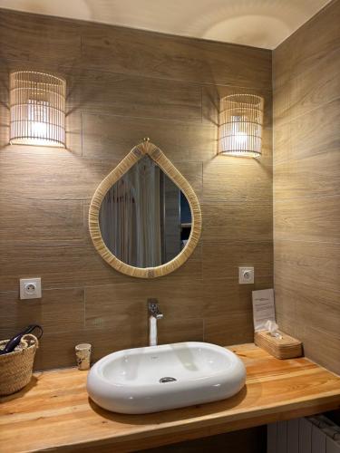 a bathroom with a white sink and a mirror at Domaine de Tameslohte in Tameslouht