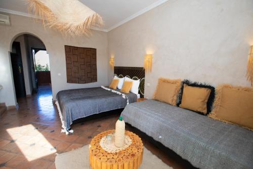 a living room with two beds and a couch at Domaine de Tameslohte in Tameslouht