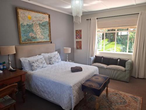 a bedroom with a bed and a couch at Burnham Road Suite Guest House in Bulawayo
