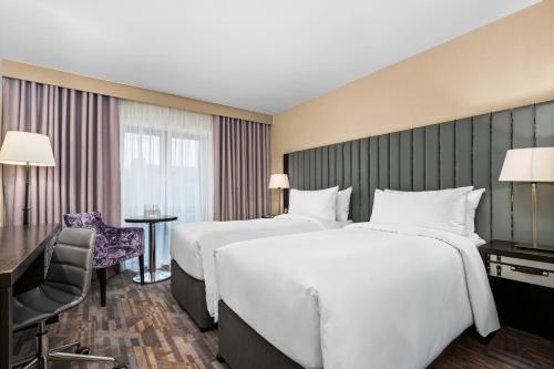 a hotel room with two beds and a desk at The Trinity City Hotel in Dublin