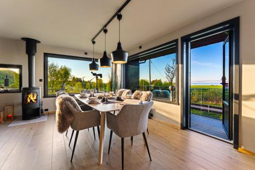 a dining room with a table and chairs and a fireplace at Villa Walter Lofoten with SAUNA in Kvalnes