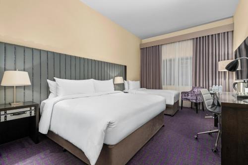 a hotel room with two beds and a desk at The Trinity City Hotel in Dublin