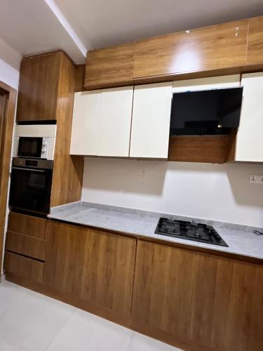 a kitchen with wooden cabinets and a stove at Waterfront 3BR Lekki Lagoon View in Maiyegun