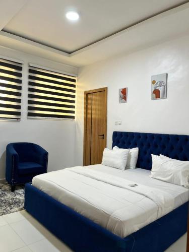 a bedroom with a blue bed and a blue chair at Waterfront 3BR Lekki Lagoon View in Maiyegun