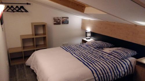 RoquevaireにあるLe Petit Clauvierのベッドルーム1室(青と白のストライプの毛布付きのベッド1台付)