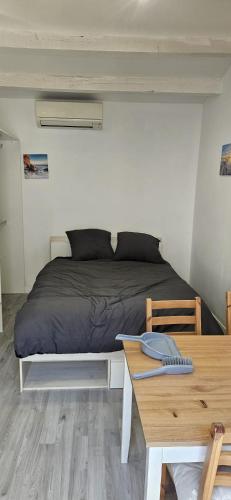 a bed in a small room with a table and a desk at cosy studio in Saint-Maximin-la-Sainte-Baume