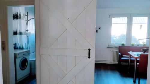 a sliding door in a room with a washing machine at Geesthaus Geestland in Geestland