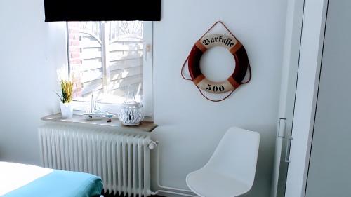 a room with a bed and a life preserver on a window at Geesthaus Geestland in Geestland