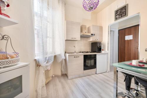 a kitchen with white cabinets and a stove top oven at Residenza Elisabetta in Verona
