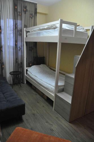 a bedroom with two bunk beds with a couch at Ski Sun & Fun - next to iconic Marco Polo in Gudauri