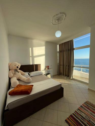 a teddy bear sitting on a bed in a bedroom at HRS Luxury Apartments in Durrës