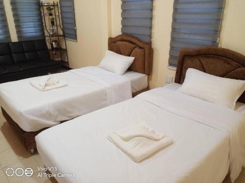 two beds with white shoes on them in a room at Limlay House in Ban Suan On