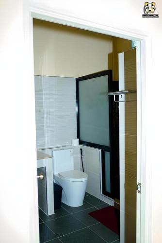 a bathroom with a white toilet in a room at Limlay House in Ban Suan On