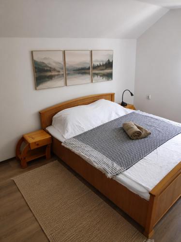 a bed in a bedroom with three paintings on the wall at villa vidalis in Veliko Golovode