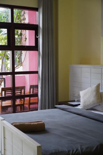 a bedroom with a large bed and a window at URALSURF HOUSE in Weligama