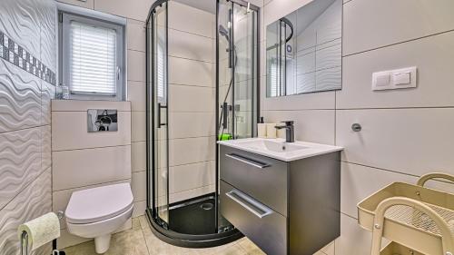 a bathroom with a shower and a toilet and a sink at Domki Izerskie in Krobica