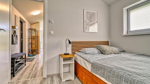 a small bedroom with a bed and a window at Domki Izerskie in Krobica