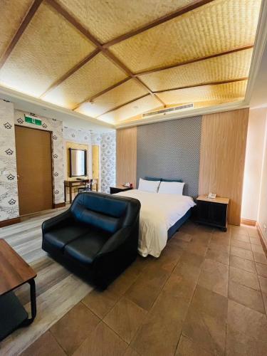 a large bedroom with a bed and a chair at Walker Motel 2 in Taipei