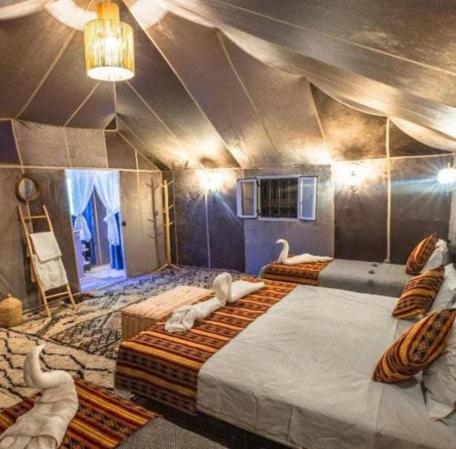 a room with two beds with swans in it at Palace desert camp in Merzouga