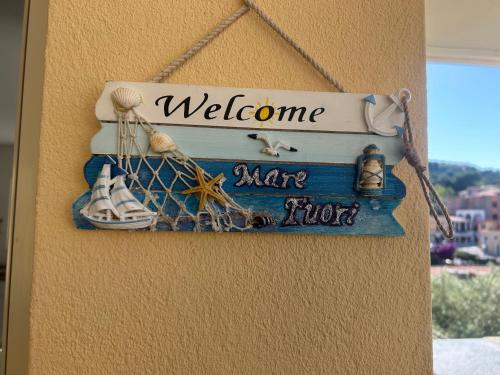 a welcome sign on a wall with shoes and a ship at Mare fuori in Villasimius