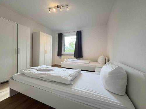 a large white bedroom with two beds and a window at LEU111 komfortable Monteurwohnung in Leuchtenberg