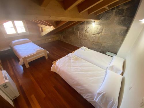 an attic room with a bed and a bench at Ático Seijas 6 in Tui