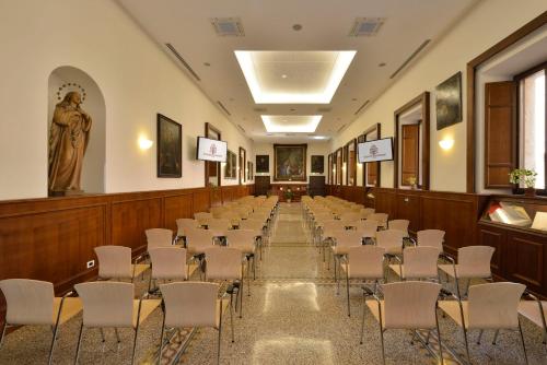 a lecture hall with rows of chairs and a statue at Casa I Cappuccini in Rome