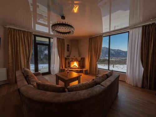 a living room with a couch and a fireplace at Villa Tba near Borjomi, Tsemi and Sadgeri in Tsemi